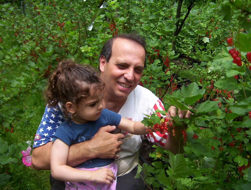 father and daughter enjoying berry bush